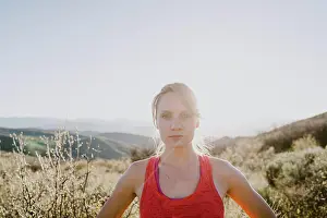 Runner Prints: Athletic blonde woman stares back at you with sun and mountains behind