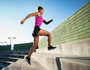 Disability Prints: Athletic woman with amputated hand running up steps