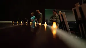 Holocaust Prints: Attendees read posters about holocaust events during a candlelight ceremony in honor of the Days of Remembrance