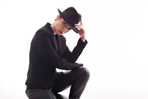 Elegance Prints: Attractive caucasian female with a stylish hat posing in studio over a white background