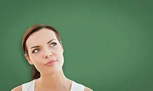 Blackboard Prints: Attractive young mixed-race woman looking up to blank chalk board