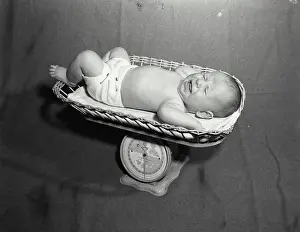 Full Length Prints: Baby crying in a weighing scale's basket