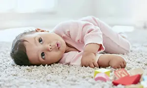 Block Prints: Baby, face and relax on carpet in home with building blocks for cognitive development