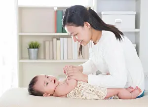 Hinreissend Prints: Baby massage. Baby massage. Asian mother massaging baby hands at home