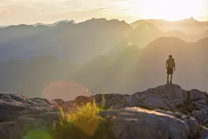 Beginnings Prints: Backpacker stands on rock outcrop, looking out at view
