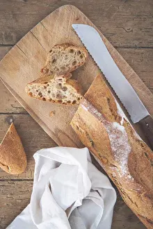 Knife Prints: A baguette is cut on a cutting board with a knife
