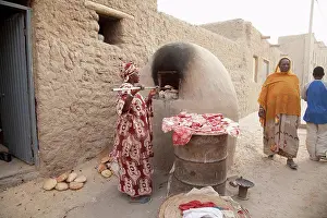 Arid Prints: Baking bread in mud oven in Timbuktu, Mali