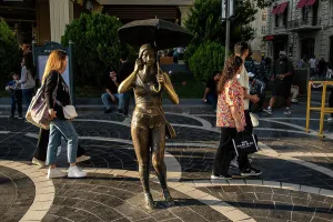 Baku, Azerbaijan Sept 22, 2024 Pedestrians pass a sculpture called Girl with Umbrella on Nizami Street