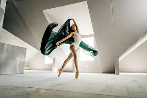 Balance Prints: Ballerina poised en pointe with flowing green fabric in a loft