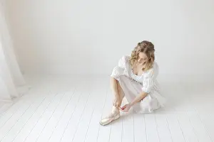 Dreamy Prints: ballerina sits on ground to remove her ballet pointe shoes