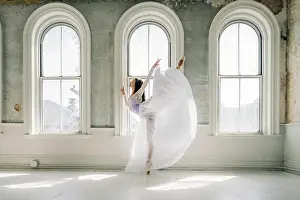 Wooden Floor Prints: Ballet dancer in a flowing white dress performs a graceful arabesque