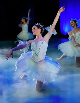 Spotlight Prints: Ballet dancers in flowing white tutus perform gracefully on a misty stage with blue lighting