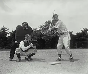 Baseball Cap Prints: Baseball player swinging a baseball bat with a baseball catcher and a baseball umpire crouching beside him