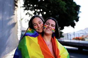 Straight Prints: beautiful lesbian couple having fun in the street with a lgtb flag