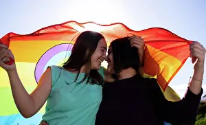 Straight Prints: beautiful lesbian couple having fun in the street with a lgtb flag