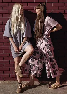 Shoulder Prints: two beautiful twin girls doing style lying in a field at sunset