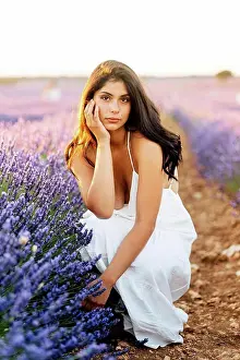 Full Length Prints: Beautiful woman crouching by lavender plants in field