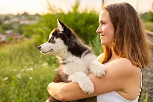 Husky Prints: Beautiful young woman is playing with her puppy dog outdoor