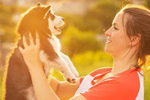 Playful Prints: Beautiful young woman is playing with her puppy dog outdoor