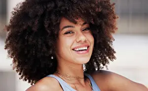Beauty, smile and portrait of a happy black woman with an afro with a positive