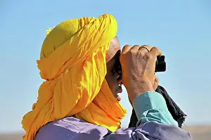 Arabic Prints: Berber with the traditional Litham turban looking for lost animals with binoculars
