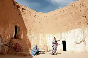 Entrances Prints: Two Berber women dressed in traditional costume in a cave dwelling