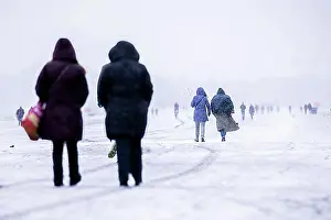 Bald Prints: Berliners walk across Tempelhofer Feld in Berlin during snowfall