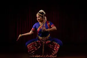 Expressions Prints: Bharatnatyam dancer sitting in muzhu mandi position in front of a dark background