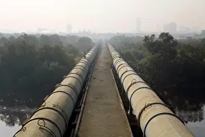 Fitting Prints: Big pipes carrying water to South Mumbai passes through Dharavi draped in smog ; Bombay Mumbai ; Maharashtra ; India