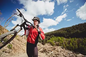 Exhilaration Prints: Biker carrying bicycle on mountain against sky