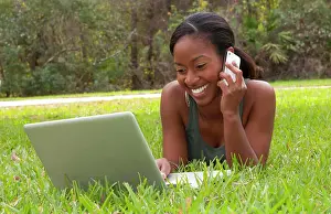 Call Prints: Black African American teen girl age 18 working on computer Facebook with emailing friends cell phone in front yard