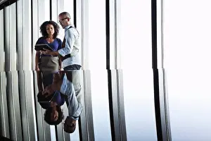 Bald Prints: Black businesswoman and Asian businessman looking at a notebook computer