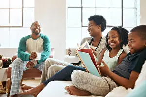 Lounge Prints: Black family, reading book and children on sofa