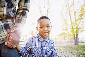 Fondness Prints: Black father and son walking in autumn leaves