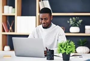 Typing Prints: Black man, smile and laptop in office for web design