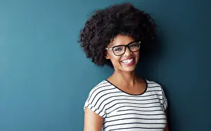 Smart Prints: Black woman, portrait and smile with glasses for optometry or vision and on blue studio background