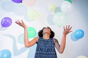 Large Group Prints: Black woman watching falling balloons