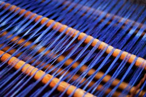 Stripes Prints: Detail of blue thread being woven at a loom