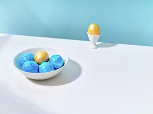 Colored Background Prints: Blue and yellow Easter eggs in a bowl and in an egg cup