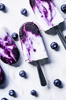 Frozen Prints: Blueberry coconut milk swirl popsicles with lime on marble background
