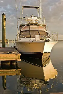 Seas Prints: Boat moored to a wharf and reflected in the water