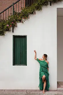 Apparel Prints: Full body barefoot female in green dress leaning on white wall of house with staircase