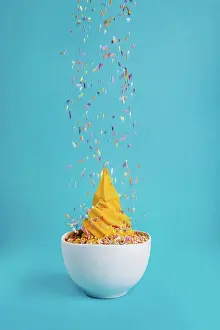 Still Life Prints: Bowl of ice cream with falling sprinkles on a blue background