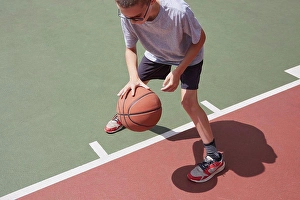 One Boy Only Prints: Boy (8-9) dribbling basketball in park
