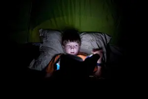 Tent Prints: Boy, 9, reading in camping tent by light