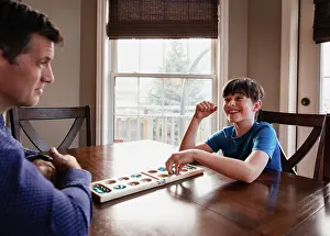 Kingston Prints: Boy and his father having fun playing a game together at home