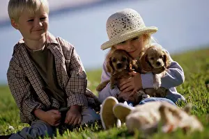 Level Prints: Boy and a girl sitting with puppies