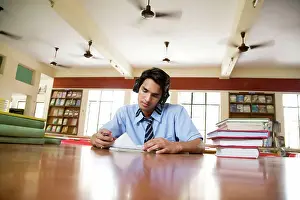 Students Prints: Boy listening to music in a library
