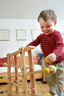 Grownups Prints: Boy playing skill game, smiling