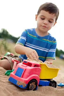 One Child Only Prints: Boy playing with toy truck on the beach, Glen Arbor, Leelanau County, Michigan, USA